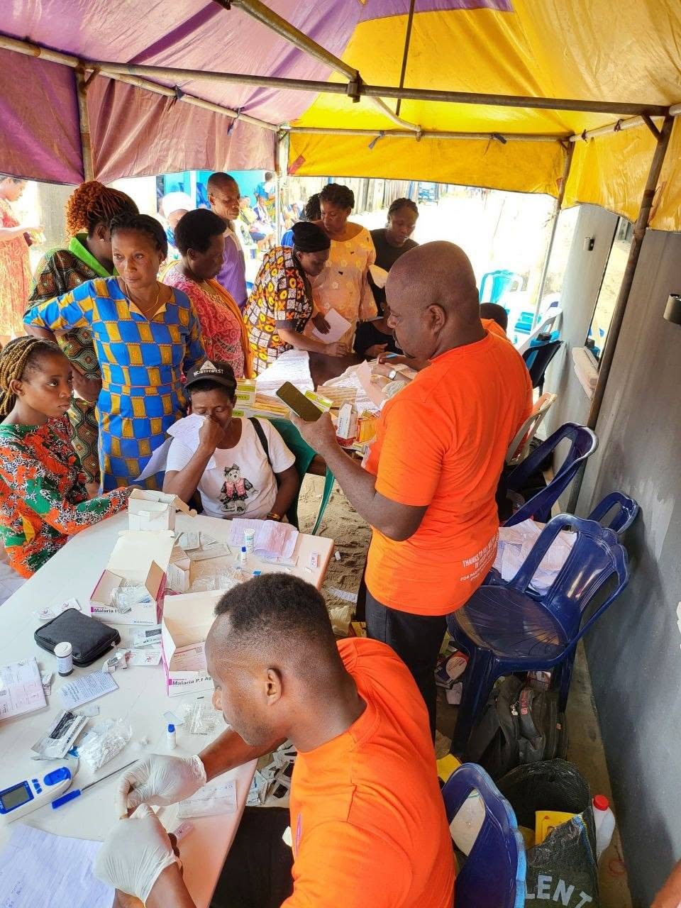 Mobile diagnostic camp with health workers and community queue